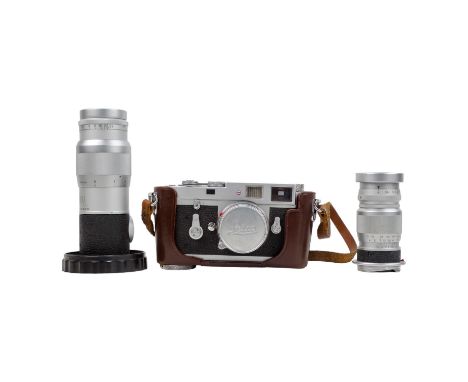 A Leitz Wetzlar Leica M2 Rangefinder camera body - serial no 1020852, circa 1961 with brown leather case and three lenses: El
