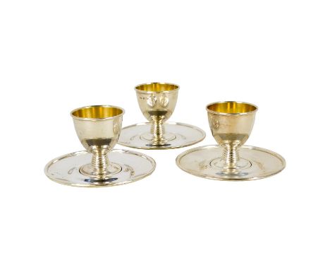 Three silver egg cups with saucers - Birmingham 1965, with gilded interiors, 234g.