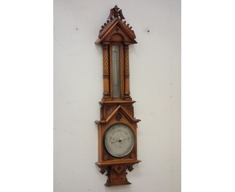 Late Victorian Gothic oak barometer, moulded pediment mounted by foliate finial, over trunk thermometer, flanked by columns, 