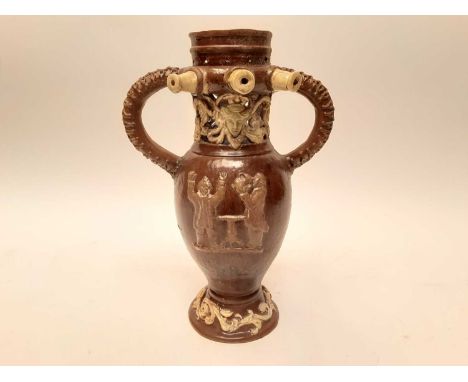 Castle Hedingham Edward Bingham brown glazed pottery puzzle jug, decorated with drinking scene, 35cm highCondition report: Ap