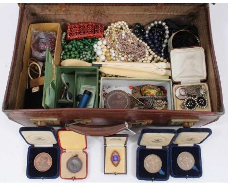 Vintage suitcase containing costume jewellery, variety of bead necklaces, old coral necklace, amber beads, ivory, sporting me