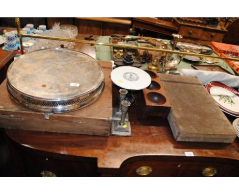 A large silver plated cake stand; a pair of silver plated candlesticks; a money box; a set of scales and a part vanity set co