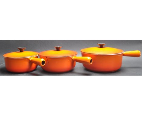 A collection of vintage 20th century French cast metal and enamel Le Creuset style kitchenware comprising of three orange lid