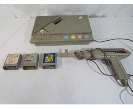 Atari - a vintage Atari XE Games Console System with light gun and three game cartridges to include Bug Hunt, Pole Position a