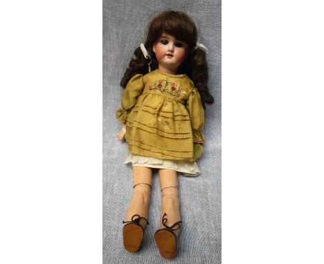 AN EARLY 20TH CENTURY DOLL with a ceramic head, stamped "Made in Germany 390 A.3.M.", with a composite body, 19.5" high with 