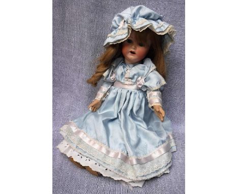 AN ARMAND MARSEILLE DOLL with a ceramic head and composite body and fixed glass eyes, 19" high circa 1920s with later clothin