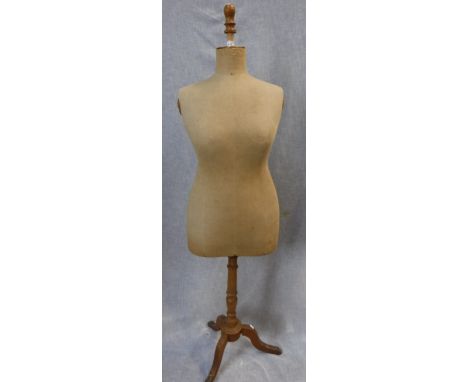 AN EARLY 20TH CENTURY CANVAS COVERED FEMALE SHOP DUMMY with turned beech tripod stand, stamped size 48, approx. 63'' high
