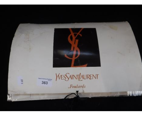 YVES ST LAURENT: A CREAM SCARF, one edge with a black and cream stripe and initialled 'YSL' in original Yves St Laurent packi
