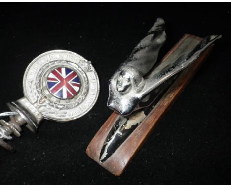 AN ART DECO CHROME CAR MASCOT in the form of a winged nude, 6.5" long and a Vintage "Royal Automobile Club Associate" badge (