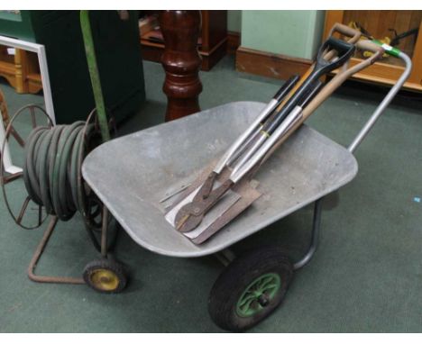 A GARDEN HOSE REEL, A SMALL SELECTION OF GARDEN TOOLS and a galvanized tipping barrow 
