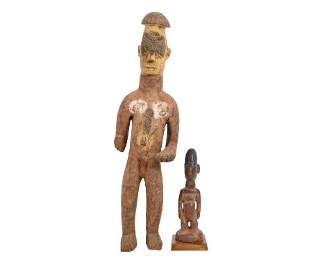 Tribal art. West Africa - an Igbo carved and stained wood figure of a standing man, 71cm h and a Yoruba carved wood figurine,