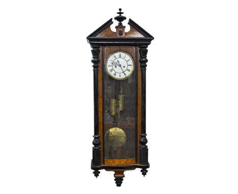 A stained and black painted walnut Vienna wall clock, c1930, brass and enamel dial, pendulum, weights and key, 115cm x 42cm w