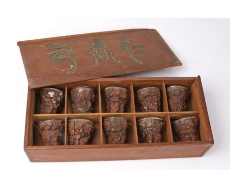 Cased set of ten Chinese carved wood and silver lined Libation cups, each with a dished silver liner and carved exterior, hos