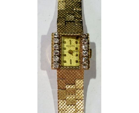 Lady's Bulova gold and diamond set wristwatch having rectangular dial, baton numerals, set two rows each of six diamonds, but