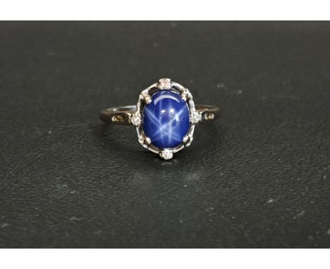 STAR SAPPHIRE AND DIAMOND RINGthe central cabochon sapphire approximately 9.7mm x 7.6mm, the surround with four diamonds, on 