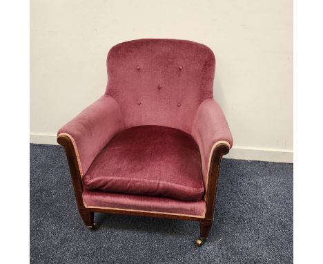 VICTORIAN MAHOGANY ARMCHAIRwith a button back and loose seat cushion, standing on tapering front supports with brass casters 