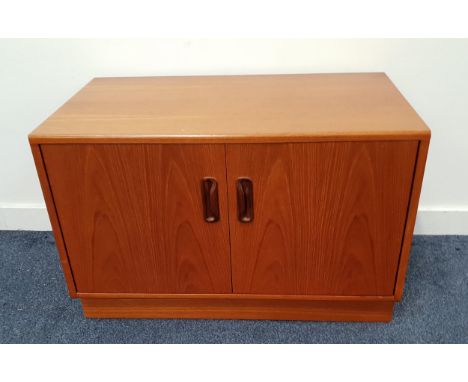 TEAK LOW SIDE CABINETwith a pair of doors opening to reveal a shelf, standing on a plinth base, 53.5cm x 81cm x 46cm 