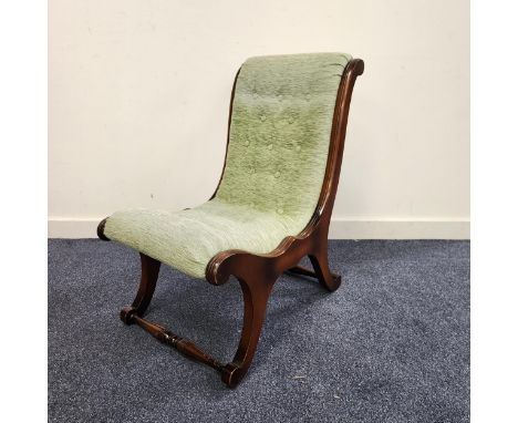 MAHOGANY SLIPPER NURSING CHAIRwith a button back and seat on shaped supports united by a stretcher 