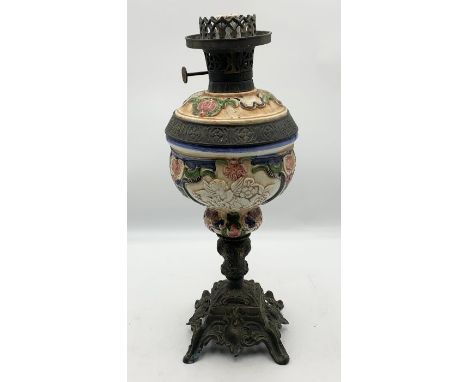 An early 20th century brass and painted ceramic oil lamp, having painted cherub and floral design raised on a brass base