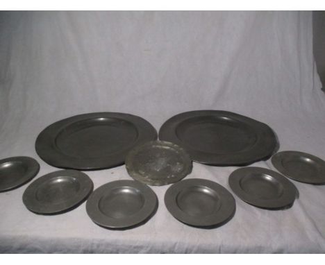 A pair of pewter chargers along with a matched set of pewter plates and one other- chargers measure 45cm diameter