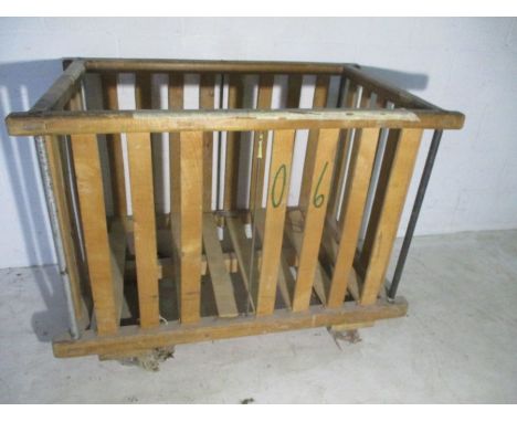 A wooden slatted industrial bobbin trolley