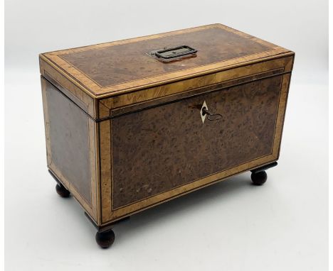 A walnut veneered tea caddy with inlaid detailing and shell design 