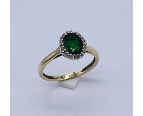 An emerald and diamond cluster ring set in 9ct gold