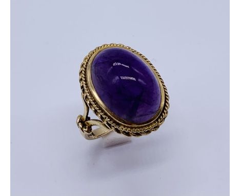 A 9ct gold ring set with a large cabochon amethyst