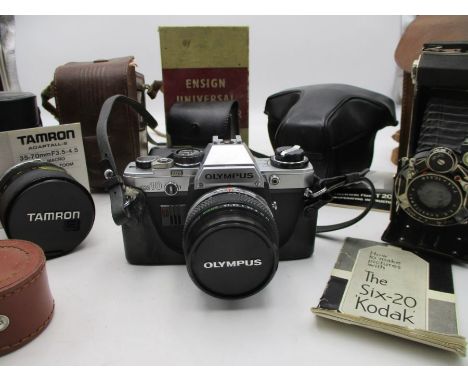 An Olympus OM10 camera with an Olympus flash, a Tamron zoom lens, a Kodak six-20, A Eumig camera, an Ensign universal film sp