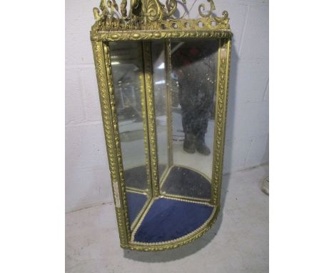 An ornate gilt framed corner mirror.