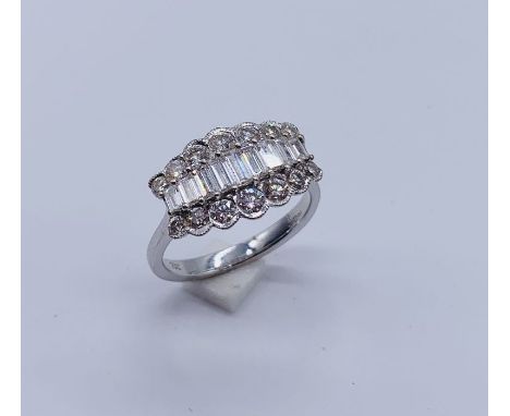 An 18ct white gold ring set with a central line of graduated baguette diamonds surrounded by two lines of brilliant cut diamo