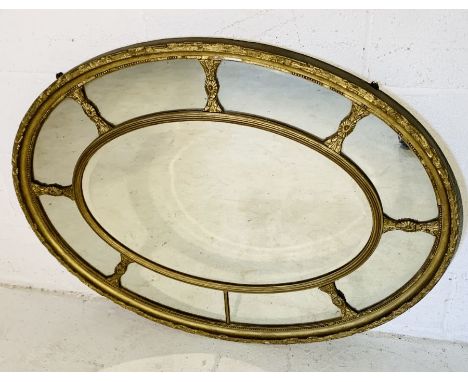 A large gilt oval mirror