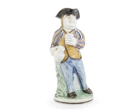 A rare 'Hearty Good Fellow' Toby Jug, circa 1800Standing contrapposto before a tree trunk, one branch forming the handle, hol