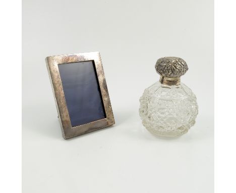 A silver and glass dressing table perfume bottle, with embossed hinged silver cover, glass stopper and bulbous glass body wit