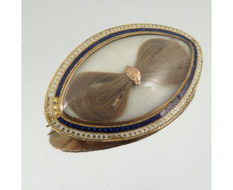 A Georgian gold and enamel mourning brooch, of oval form set with a bow of hair, to blue and white enamel bands, the back eng