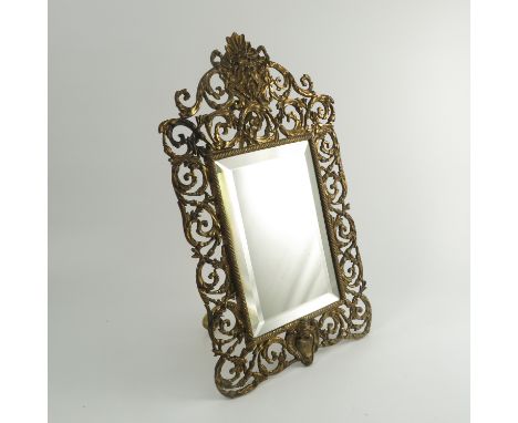 A 19th century gilt metal framed mirror, the rectangular bevelled plate with a frame decorated with a mask and scrolling leav
