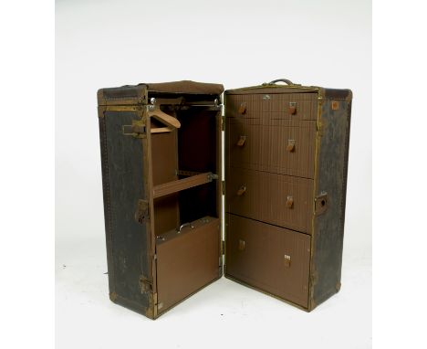 A mid 20th century fitted travelling trunk, opening to reveal various drawers, hanging space and a case, with various travel 