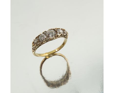 A five stone diamond ring, stamped 18ct, the graduated old cuts totalling approximately 0.8 carats, the carved head mount fin