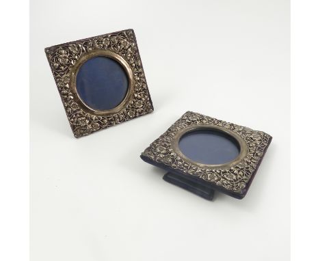 A pair of silver mounted photograph frames, with circular apertures, the pierced silver mount decorated with scrolling leaves