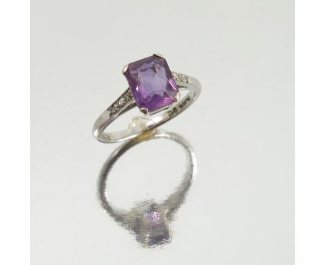 An amethyst single stone ring, the white mount stamped 'Plat 9ct' with a trio of rose cut diamonds to each shoulder, finger s