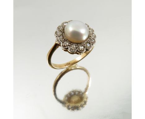 A diamond and pearl cluster ring, the button pearl (untested and unwarranted) of approximately 8.4mm diameter, enclosed by fo
