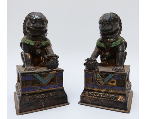 A pair of Chinese silver models in the form of Dogs of Fo, set with enamel and engraved detail, on a rectangular base, 12cm t