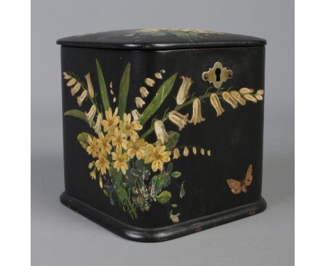 A papier mache tea caddy, with hinged lid and applied floral detailing.  Scuffing to decoration front left corner. Wear to ba