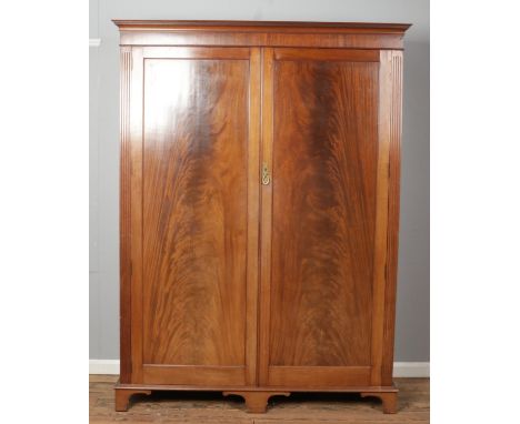 An Edwardian mahogany double wardrobe bearing label for WH &amp; EW Green Ltd. Height 216cm, Width 161cm, Depth 61cm.