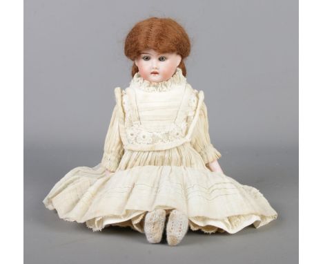 An Armand Marseille bisque headed doll, in Victorian laced dress and having brown hair with sleeping grey eyes. Stamped AM-10