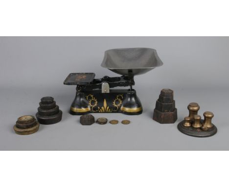 A painted set of weighing scales, with several part sets of weights.