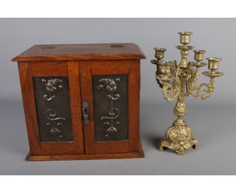 An Art Nouveau oak smokers cabinet with decorative metal panels and a cast brass candelabra Hx31cmWx34cmDx18cm  Chip to cabin