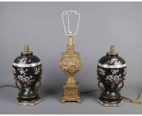 A pair of black baluster form lamps with hand painted floral decoration with another composite gilt colour grape vine design 