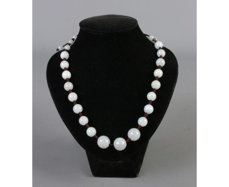 A graduated jade bead necklace, with adjustable string. Length 58cm, largest bead 1.5cm.
