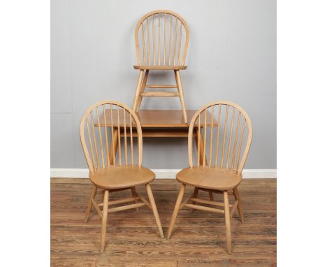 An Ercol 393 dining table along with three spindle back chairs. Table height 73cm, top dimensions 100cm x 69cm.  Split to tab